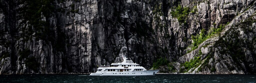 a greener charter - superyacht daydream beneath rock face