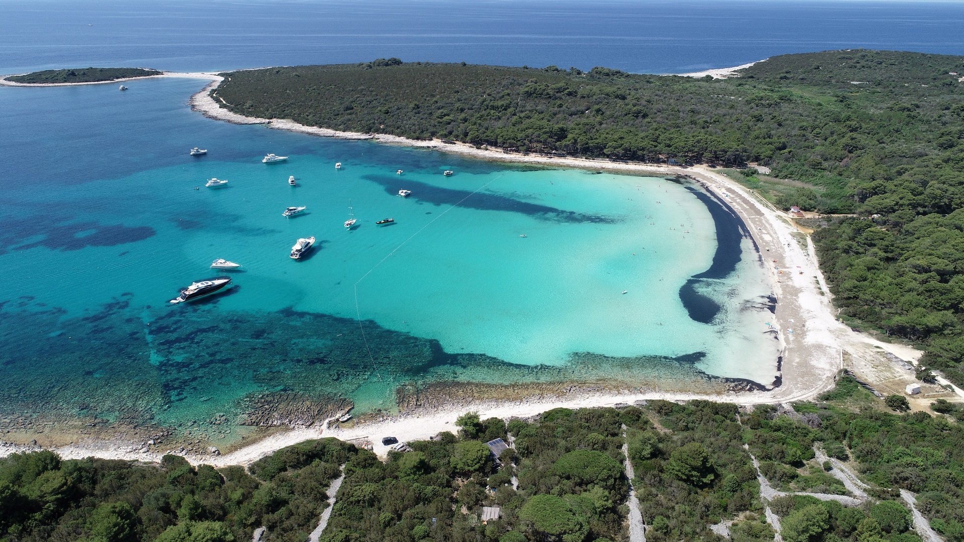 Croatia white sand beach with yachts at anchor 