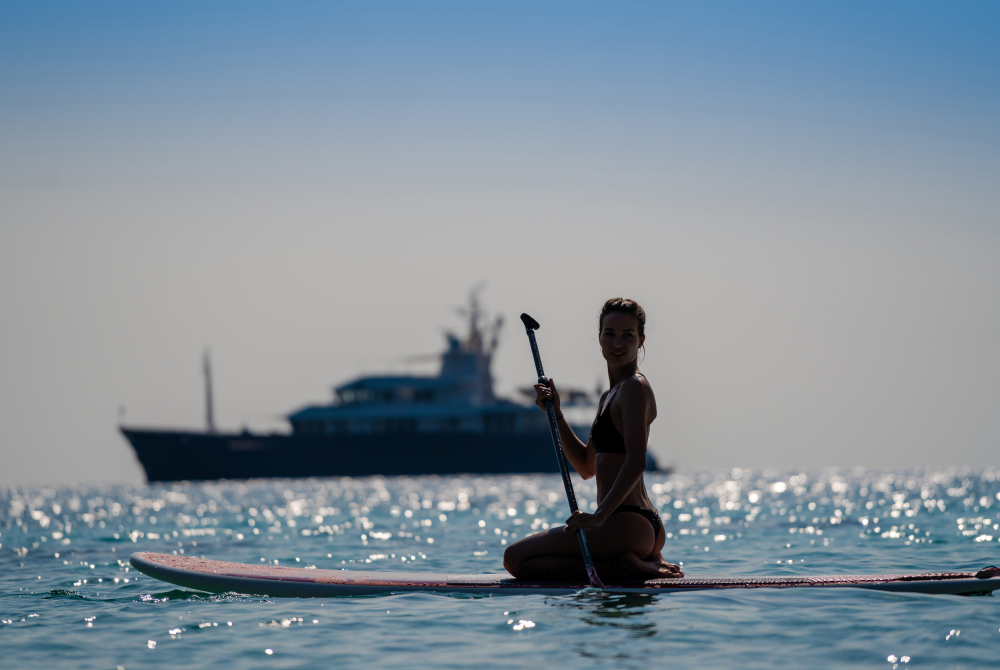 Paddle boarding in front of yacht